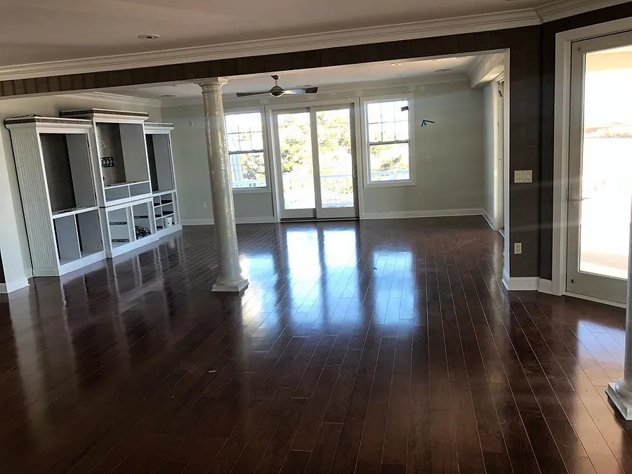 Great room with a dark hardwood floor, columns and built-ins