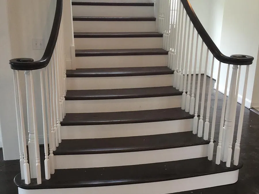 Staircase with dark hardwood treads, white risers and white balusters